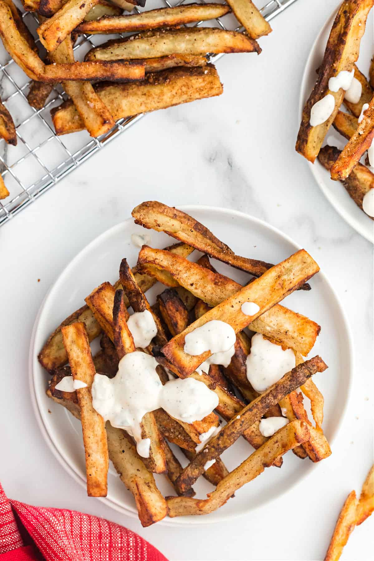 Blue cheese dressing drizzled on a plate of baked french fries.