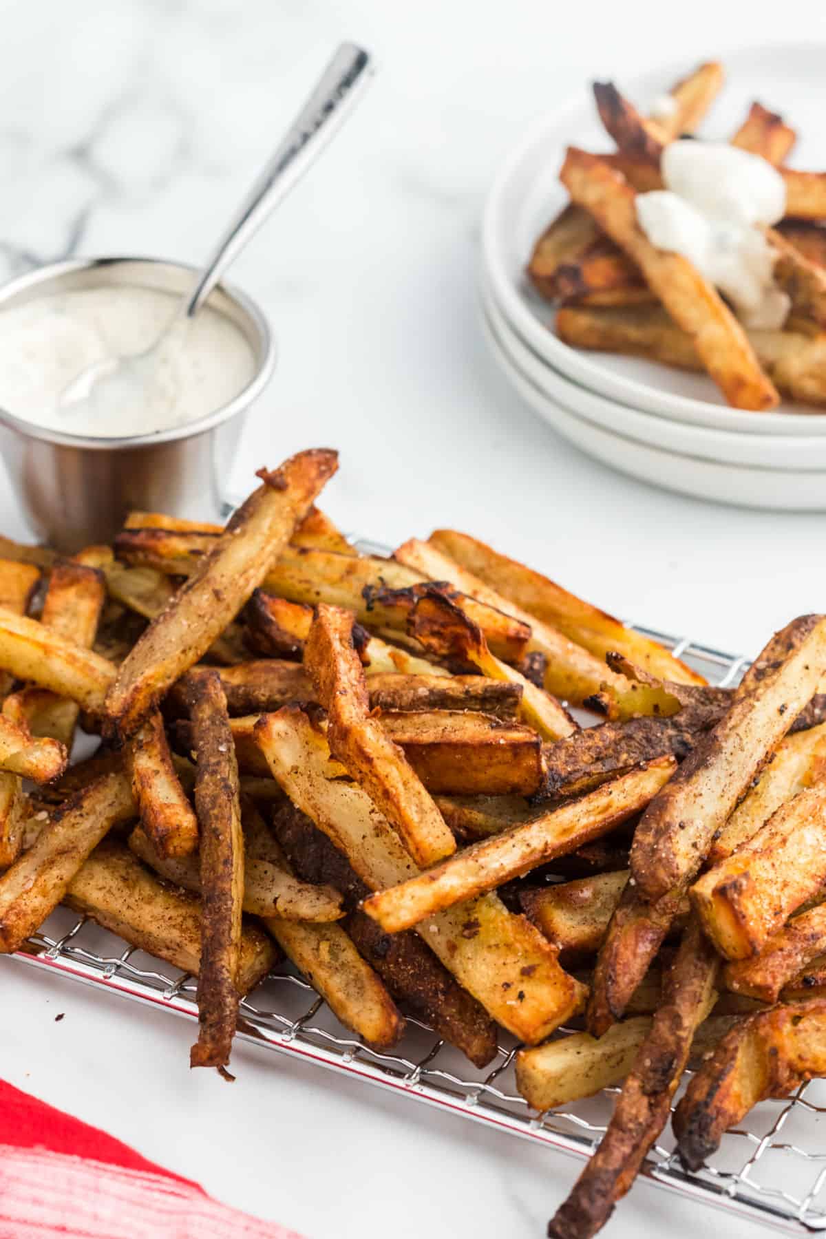 Baked french fries with a side bowl of blue cheese dressing.