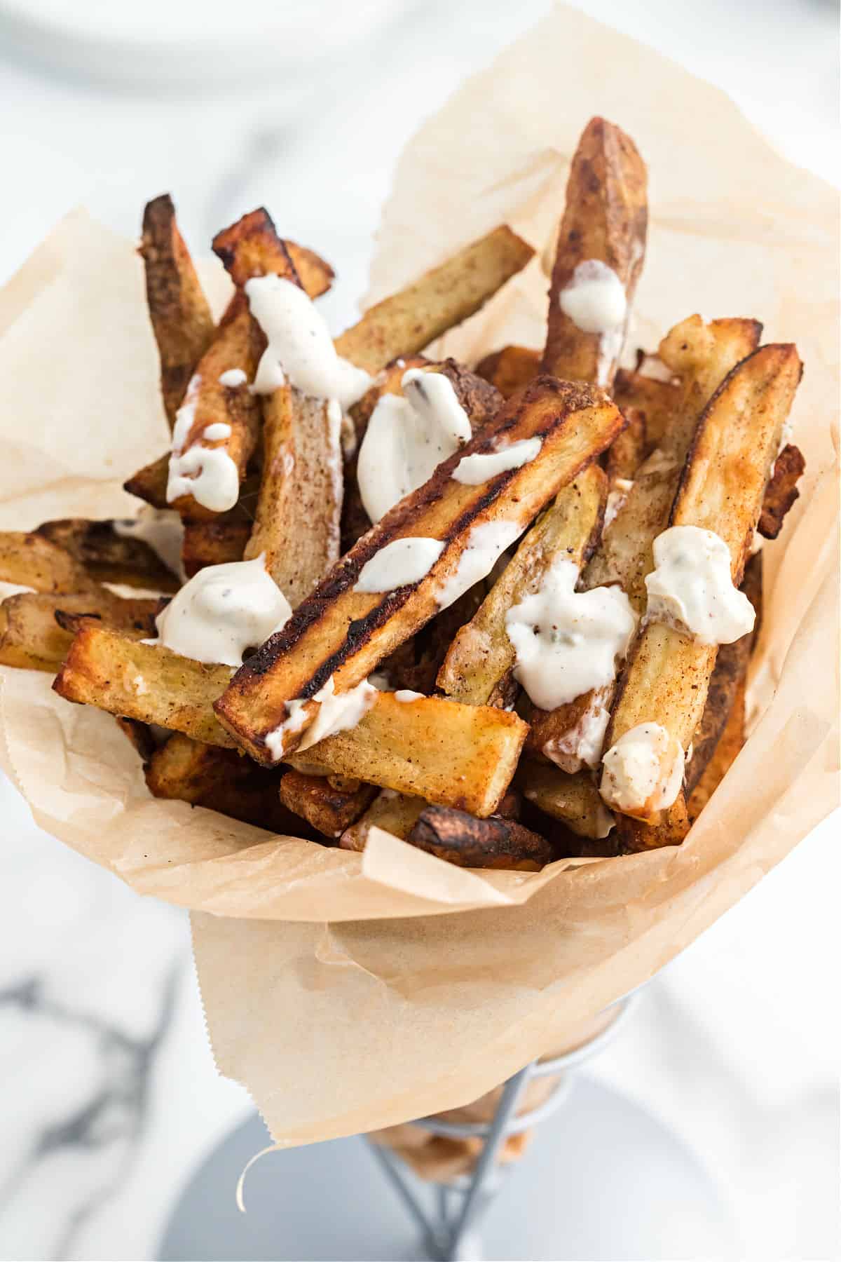 Baked french fries with bleu cheese dressing in a basket for serving.