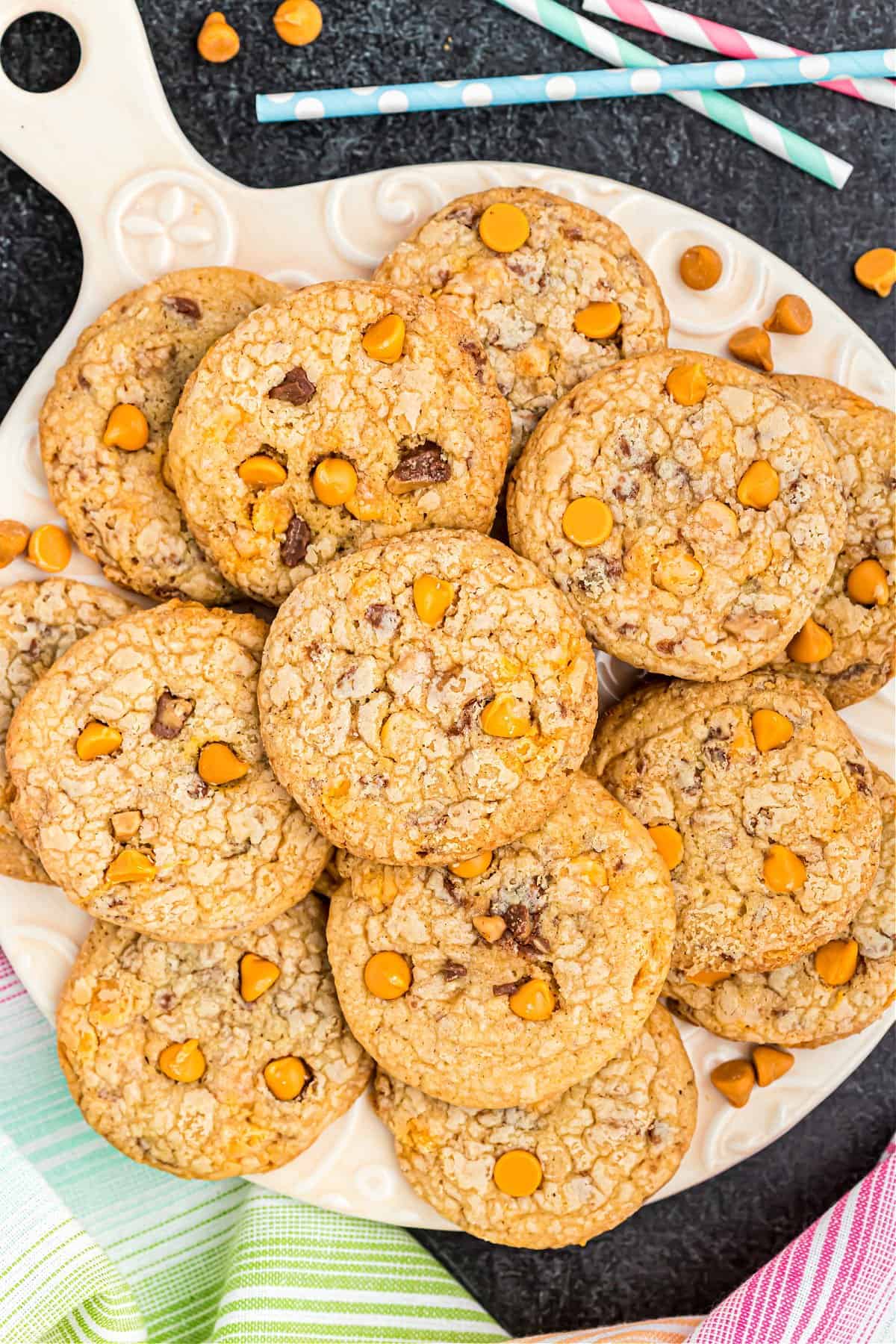 Butterscotch cookies with toffee bits on wooden paddle.