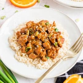 Orange chicken served over plate of rice.