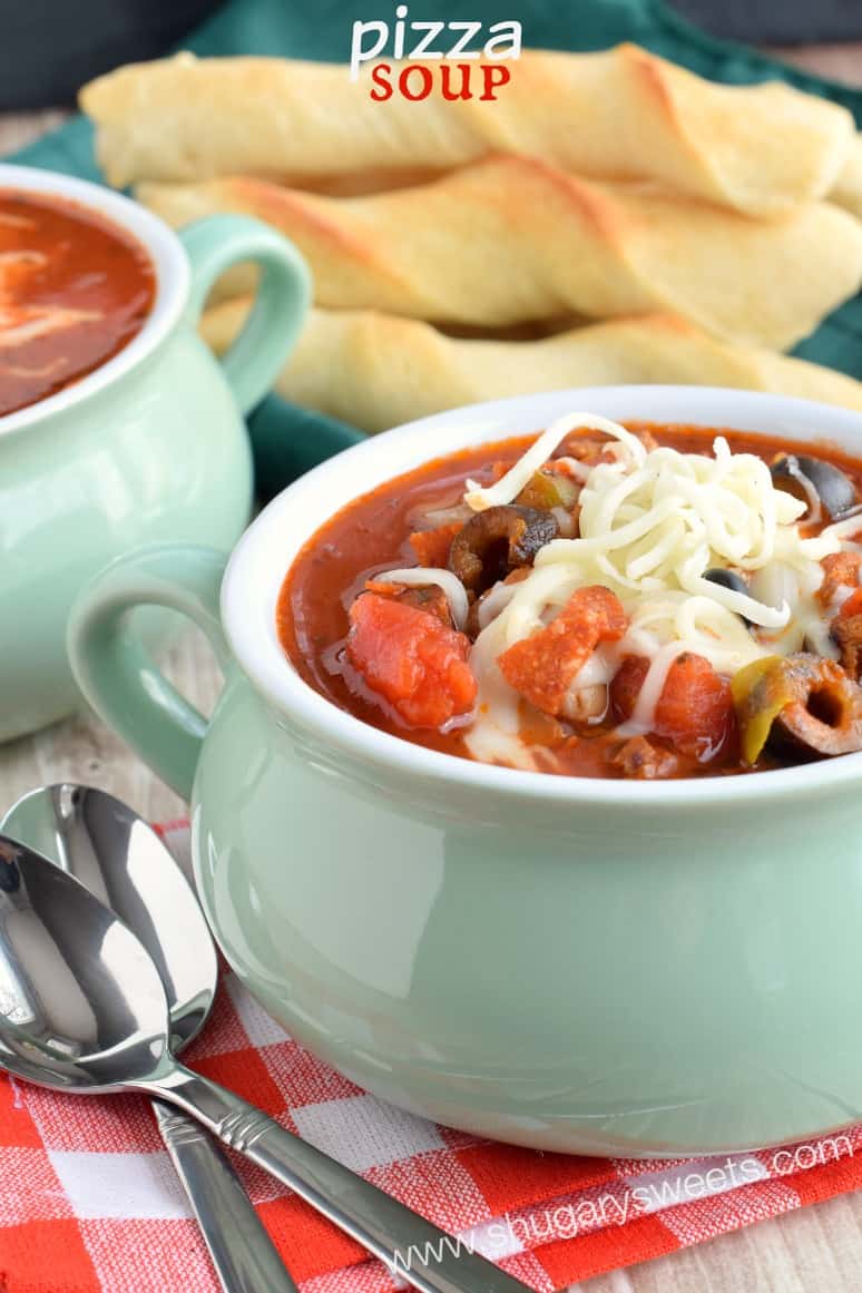 Pizza soup topped with melted mozzarella cheese in a green bowl.