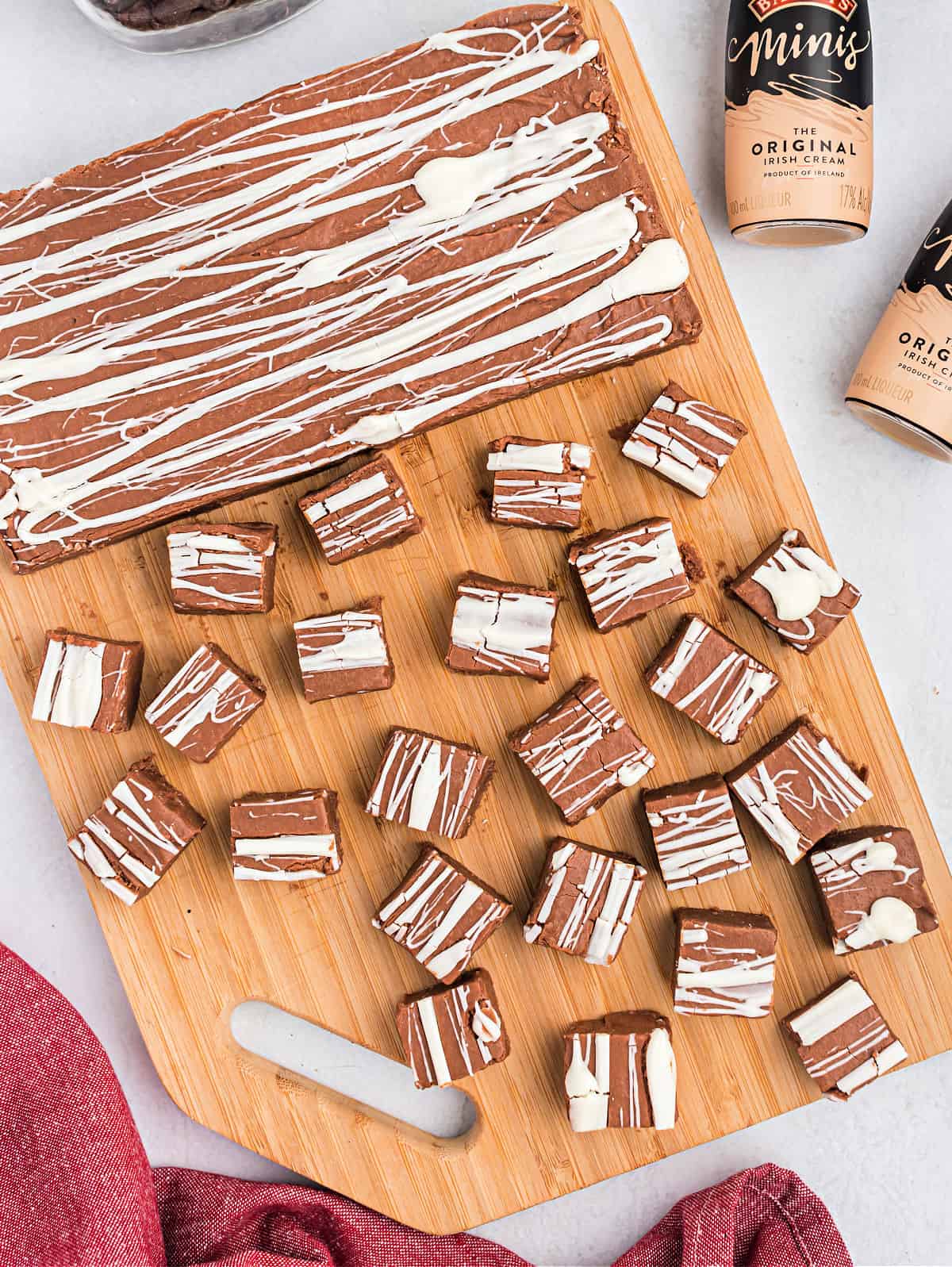 Pieces of irish cream fudge cut on a wooden cutting board.