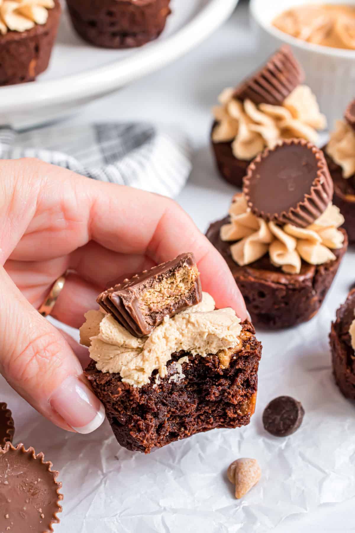 Mini brownies with peanut butter frosting and one bite removed.