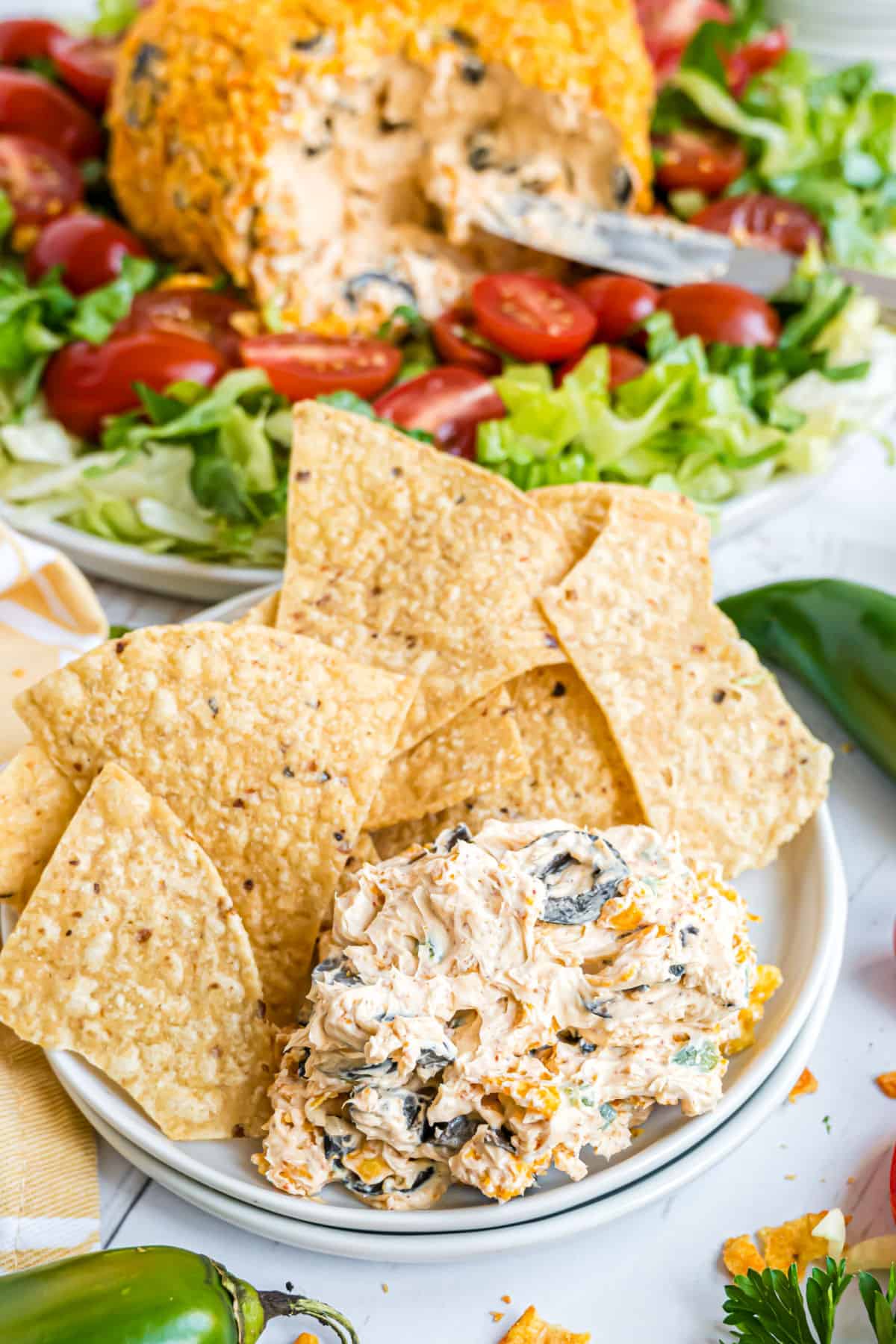 Taco cheeseball served on a plate with tortilla chips.