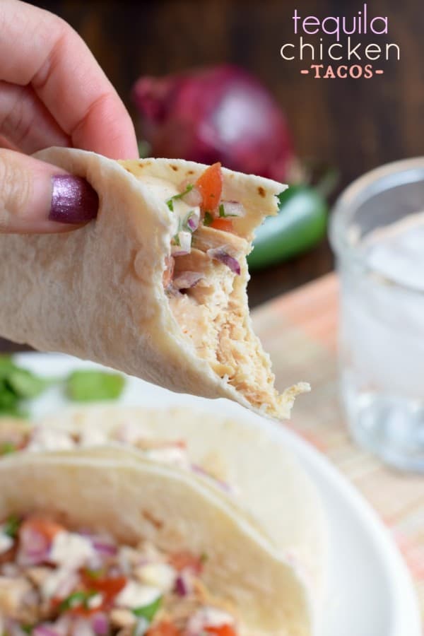 These Tequila Chicken Tacos are made in the slow cooker and topped with fresh pico de gallo and jalapeno cream!