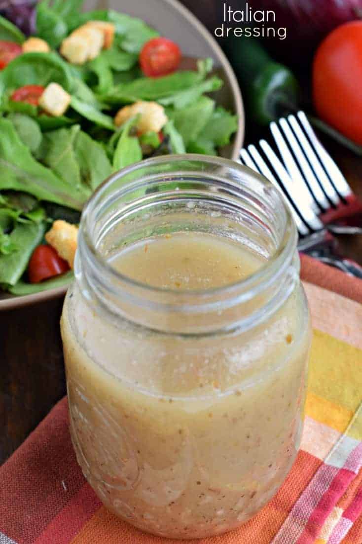 Homemade Italian dressing recipe: perfect on salads or use as a marinade for poultry! Italian dressing made from scratch in a mason jar, on a red and orange linen.