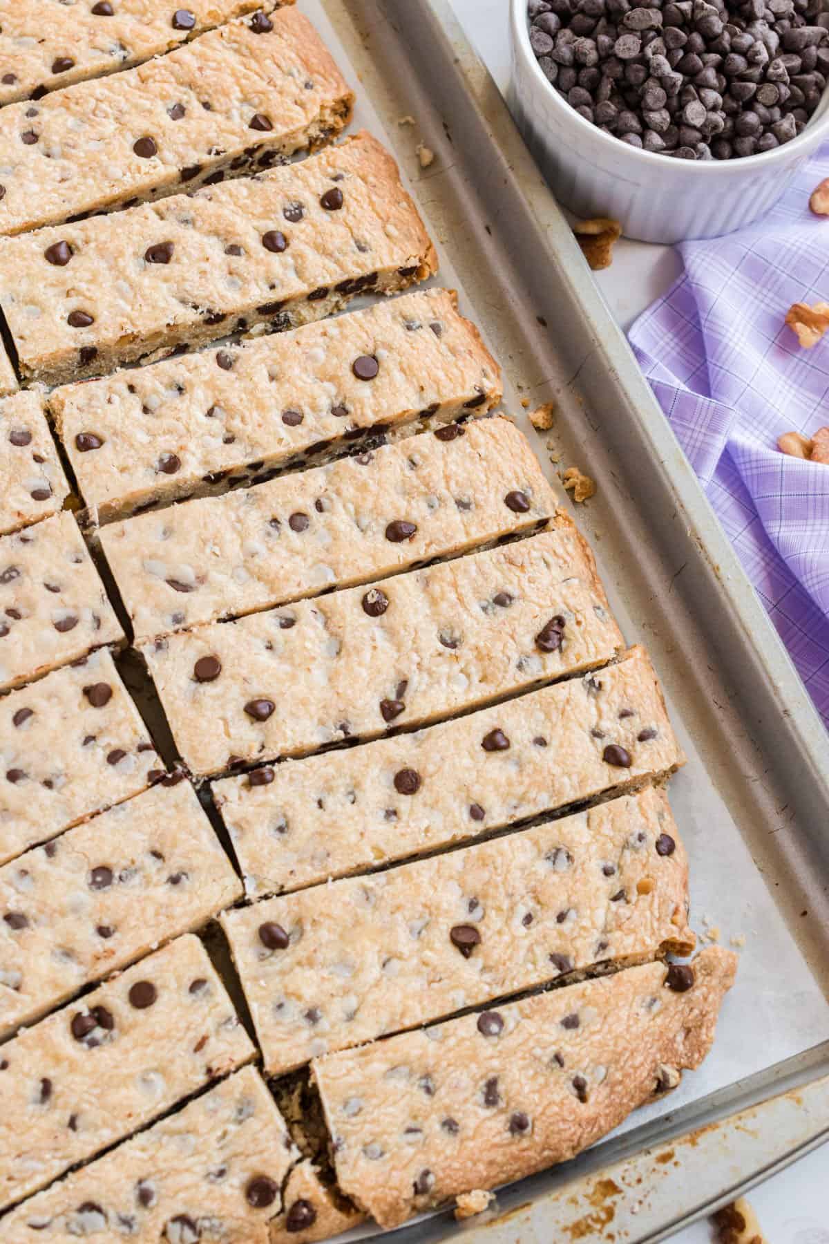 Shortbread cookies on a parchment paper lined cookie sheet cut into sticks.