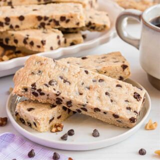 Stack of three chocolate chip shortbread cookie bars with nuts.