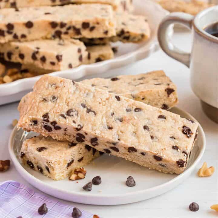 Stack of three chocolate chip shortbread cookie bars with nuts.