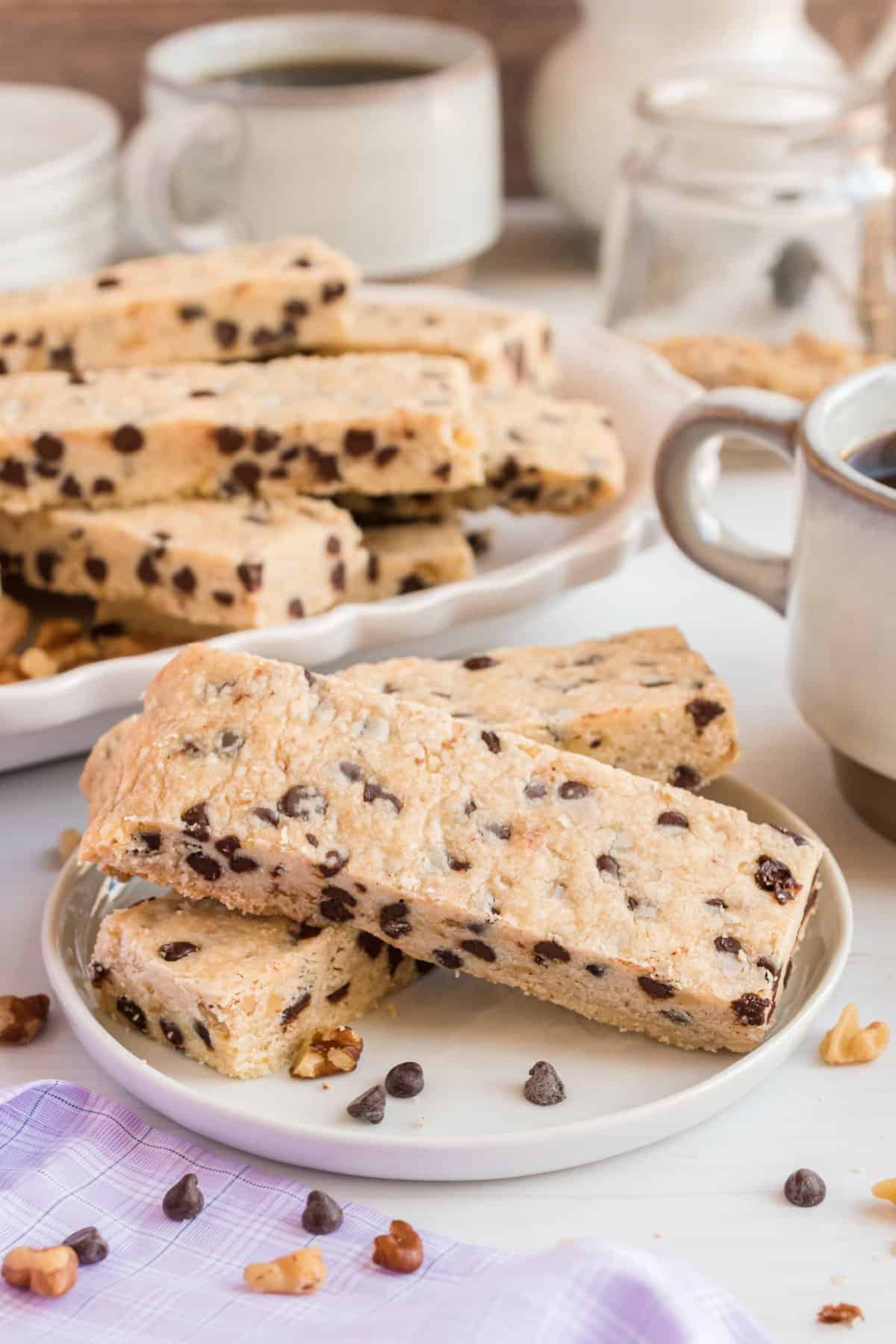Chocolate chip shortbread cookie sticks on a white plate.
