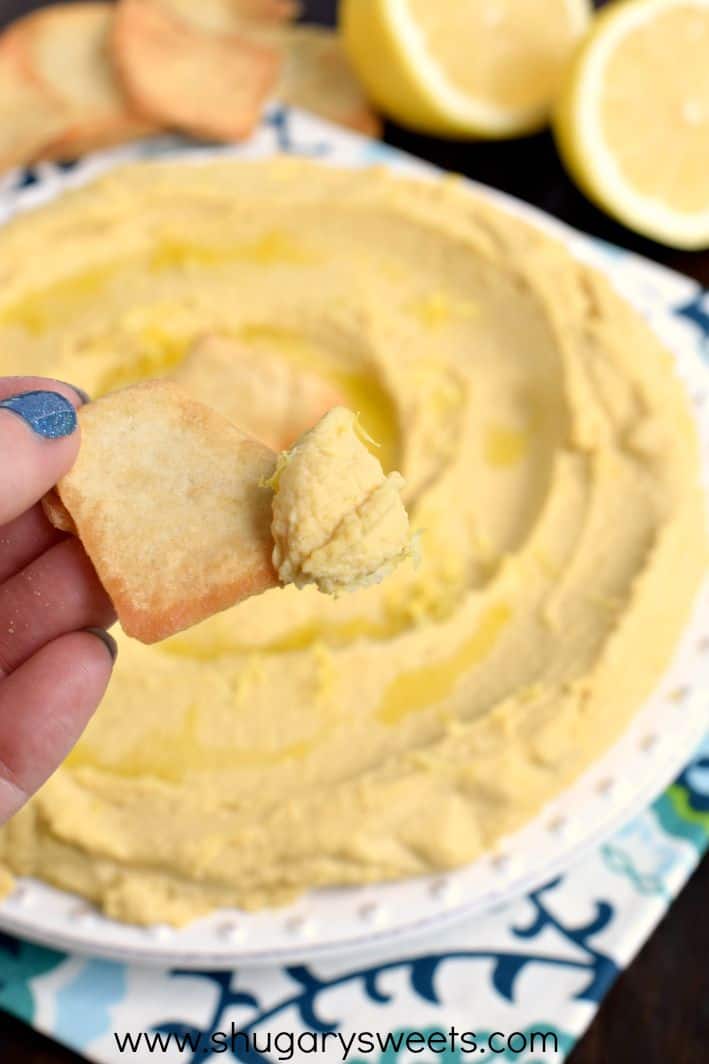 Scoop of lemon hummus on a pita chip.