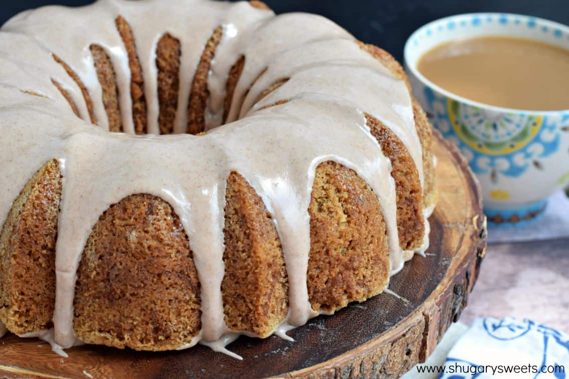 Zucchini cake on a wooden cake plate with cinnamon glaze.