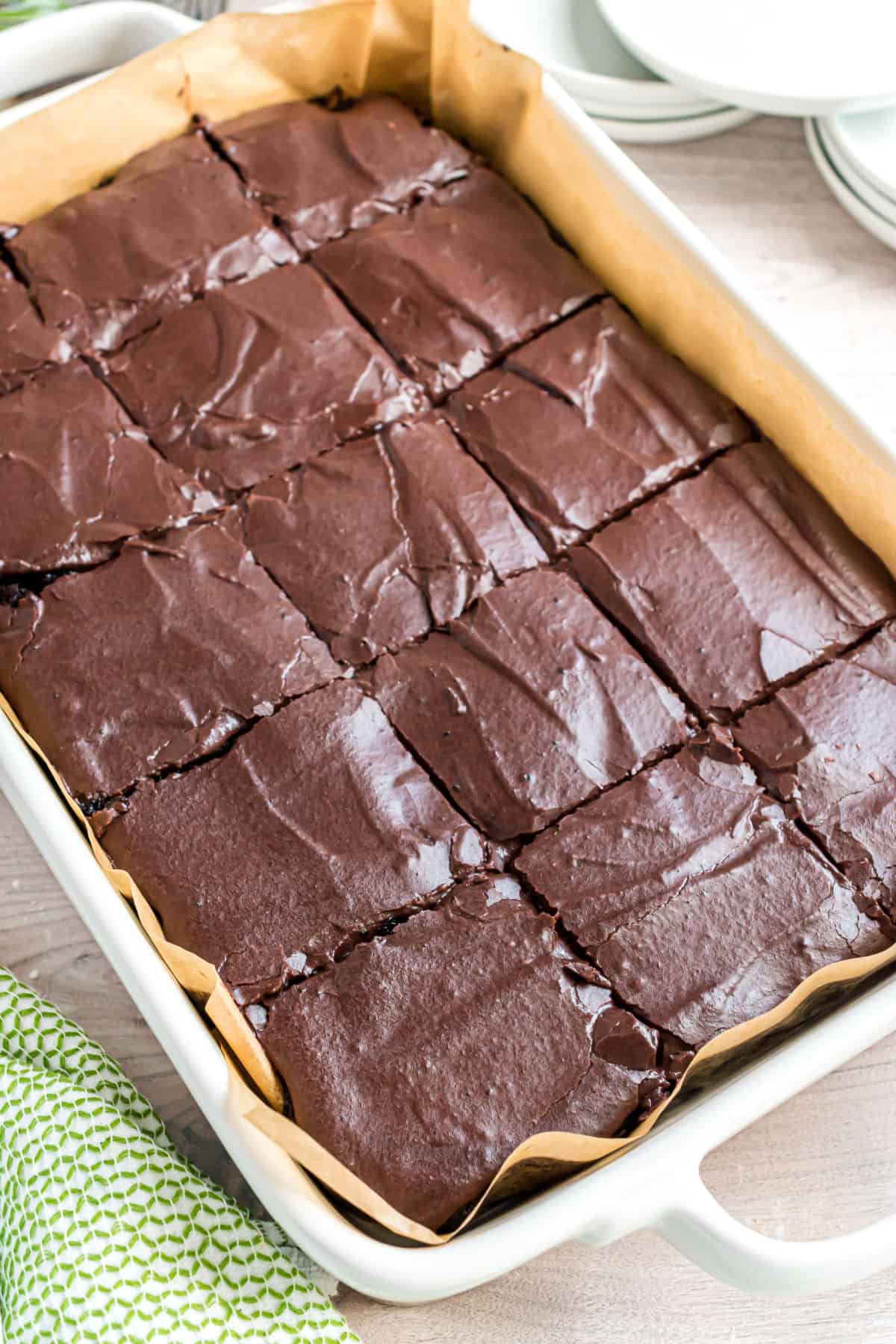 13x9 baking dish with frosted zucchini brownies, cut into squares.