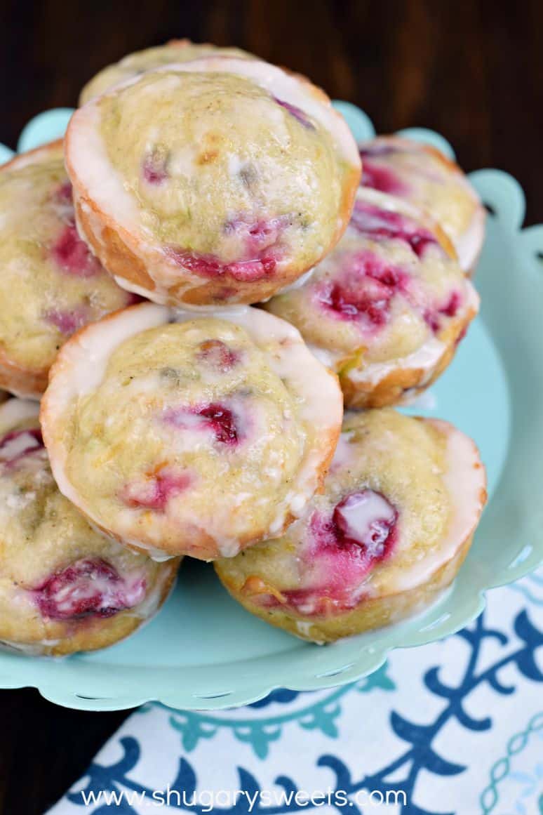 Muffins with cranberries stacked on a light blue cake platter.