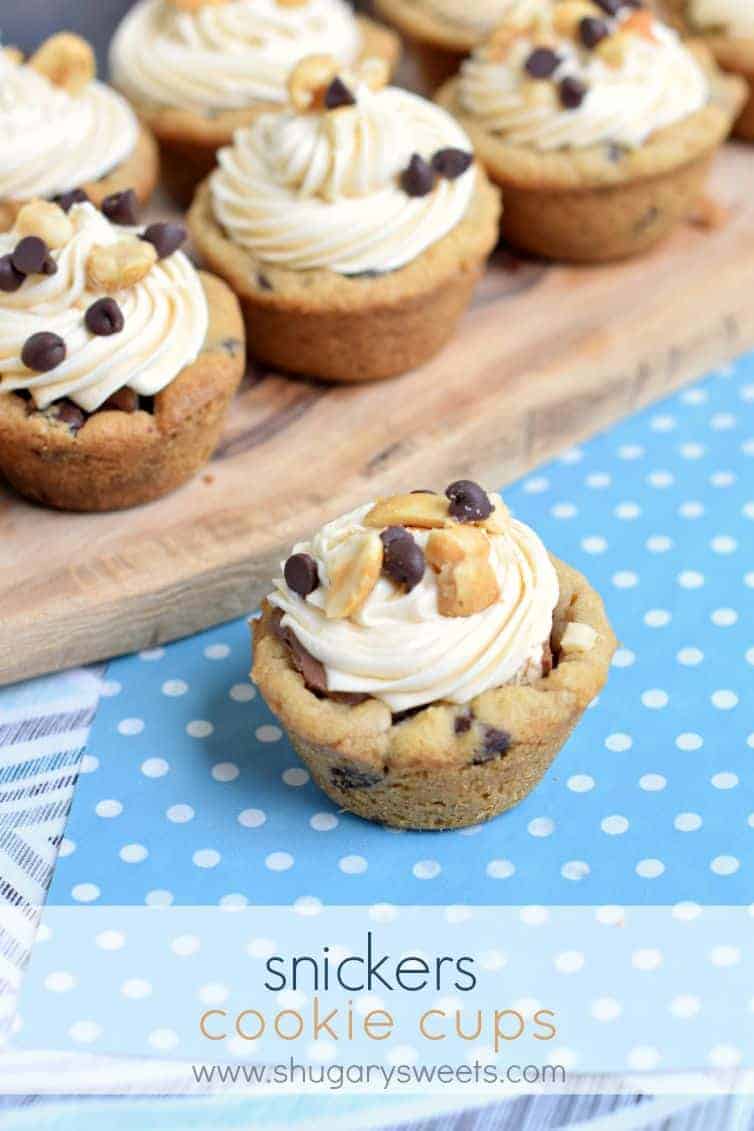 Chocolate chip cookie cups with a snickers filling and caramel frosting. On a light blue with white polka dot linen.