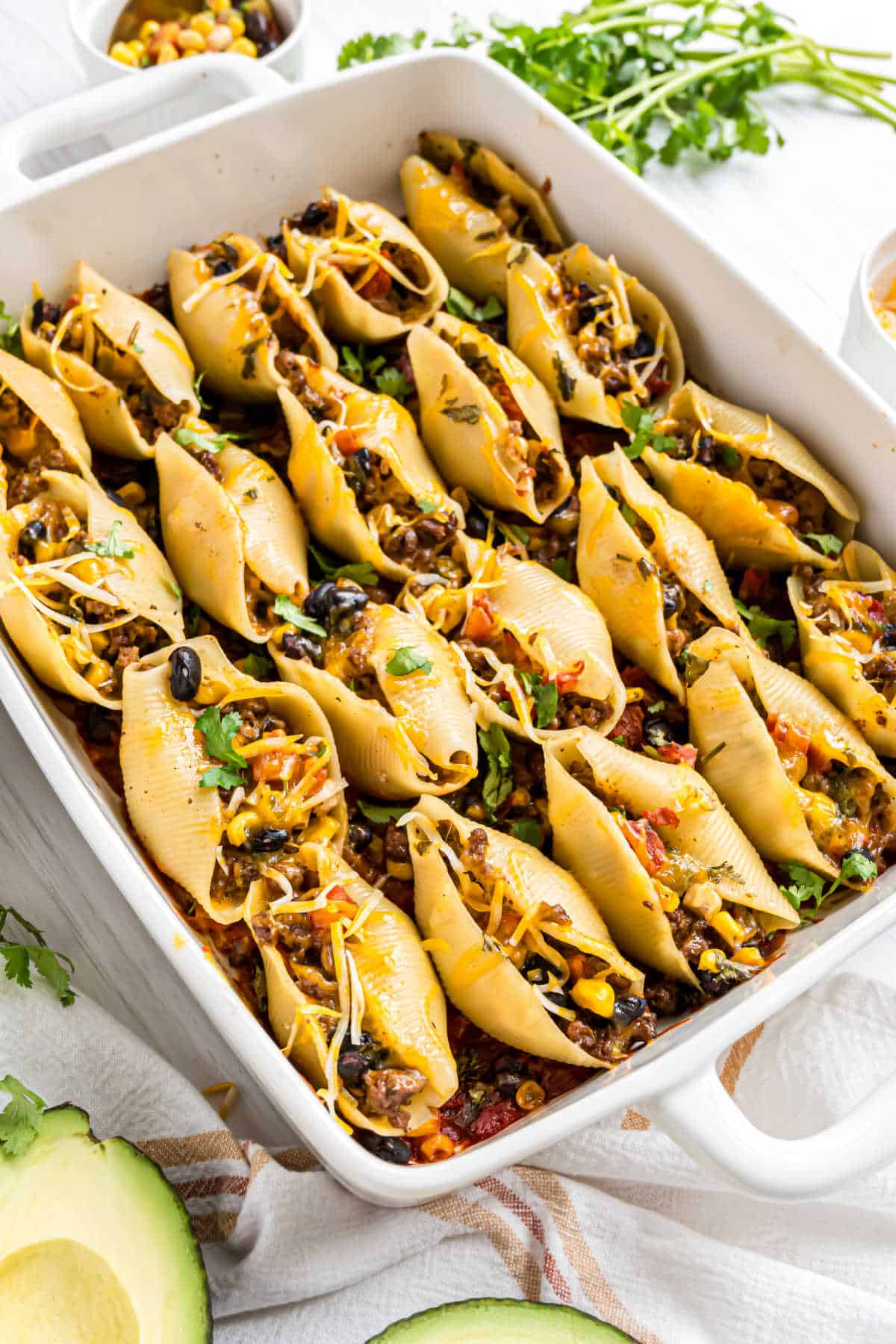 Taco stuffed pasta shelolos in a large baking dish,
