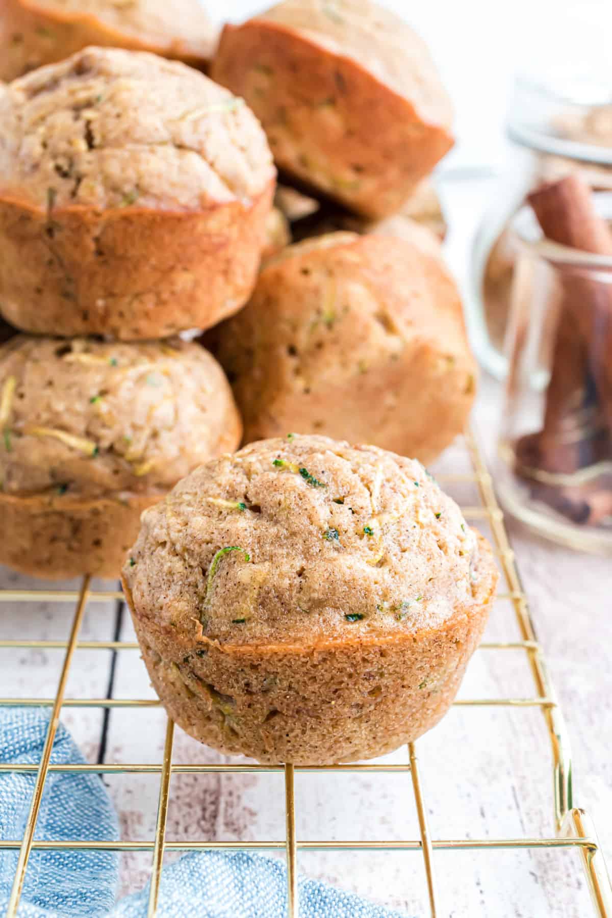 Zucchini muffins on a gold wire cooling rack.