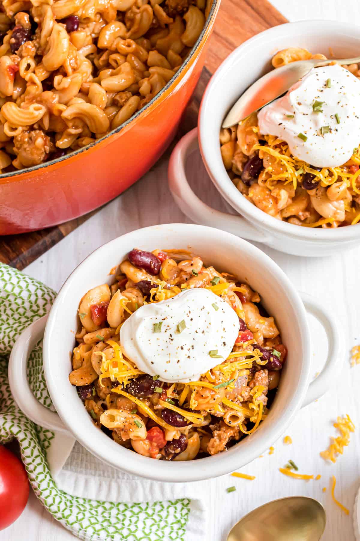 Chili mac in a serving bowl with sour cream.