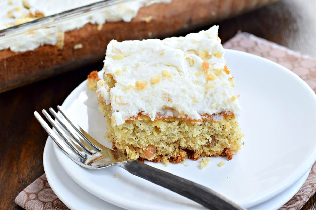 Slice of macadamia nut banana cake on white plate.