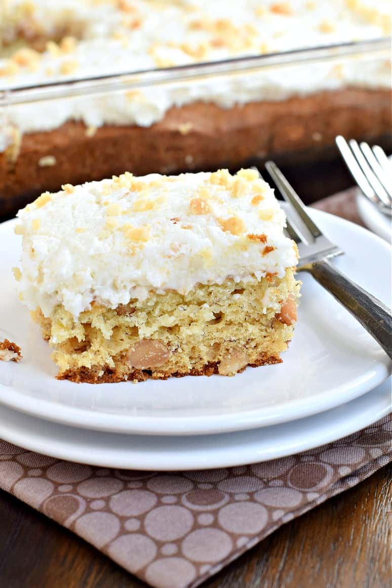 Slice of banana macadamia nut cake on a white dessert plate.