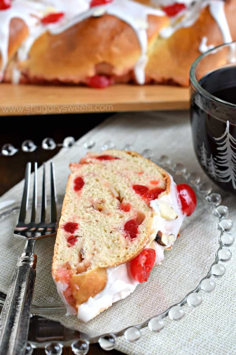 Slice of cherry almond braid on clear glass plate.