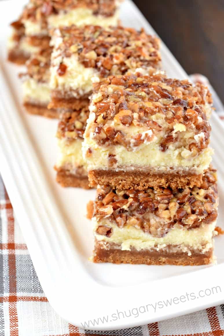 Pecan pie cheesecake layered bars on a white serving dish.
