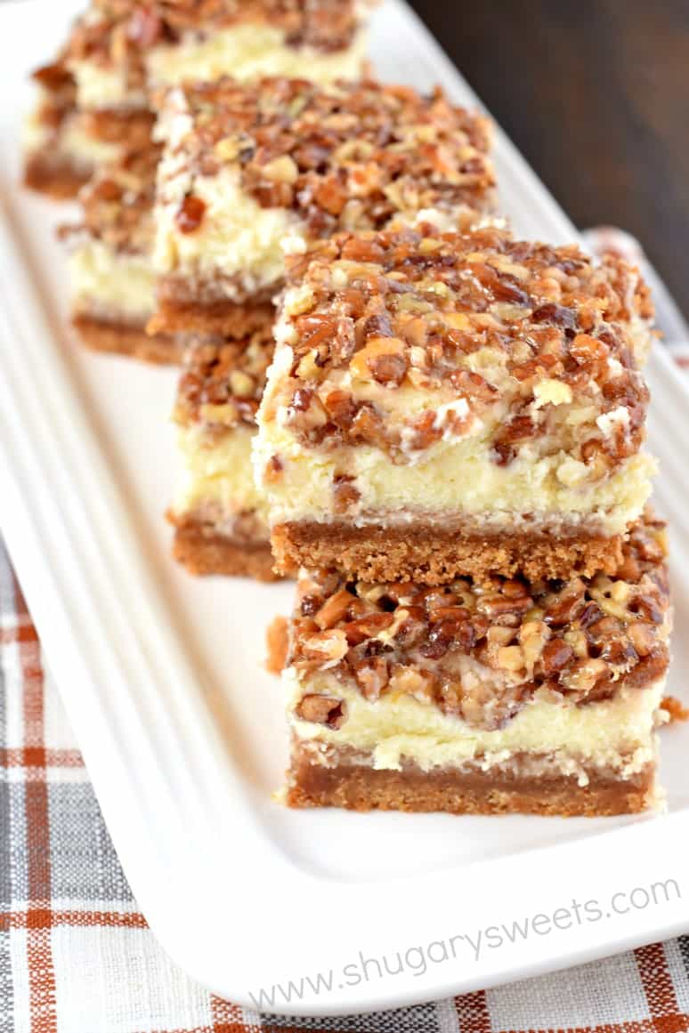 Pecan pie cheesecake layered bars on a white serving dish.