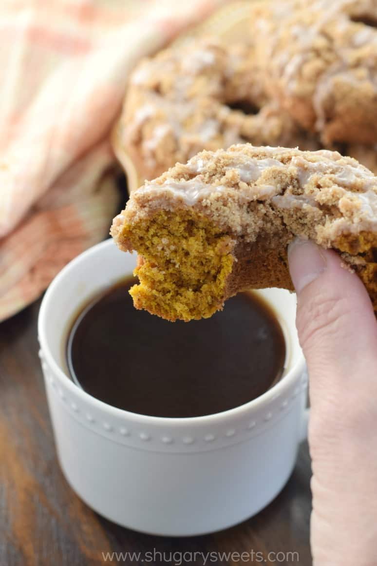 Pumpkin Streusel donuts with glaze being dunked in black coffee.