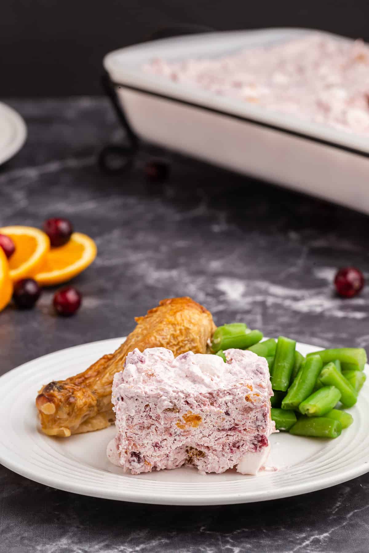 Cranberry salad on a white plate with turkey and green beans.