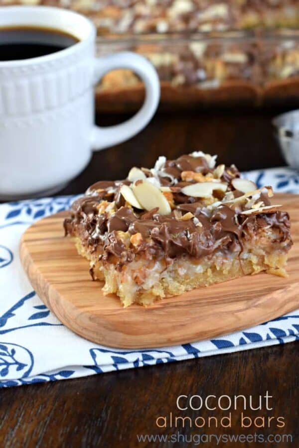 These Coconut Almond Bars are a delightful homemade candy bar recipe filled with toasted coconut and topped with chocolate, caramel, and crunchy almonds!