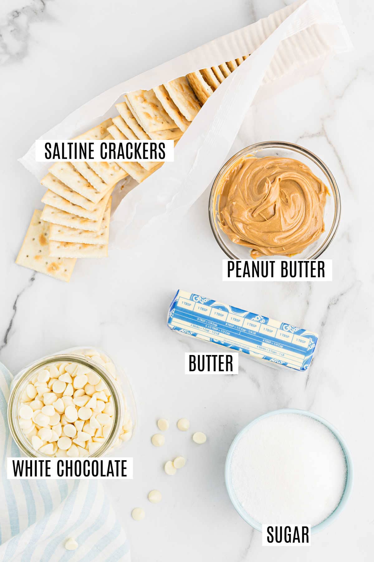 Saltine crackers, creamy peanut butter, butter, white chocolate chips, and sugar come together to create a delicious peanut butter cracker toffee arranged on a marble surface.
