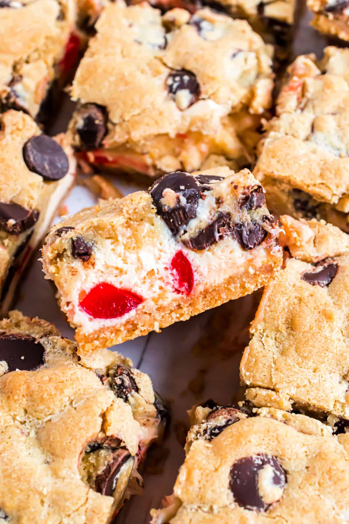 Cherry chocolate chip cheesecake bars cut into squares.