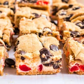 These Cherry Chocolate Chip Cheesecake Bars have a vanilla cookie crust and a creamy cherry cheesecake filling. Chocolate chip cookies baked on top take these cheesecake bars to the next level of deliciousness.
