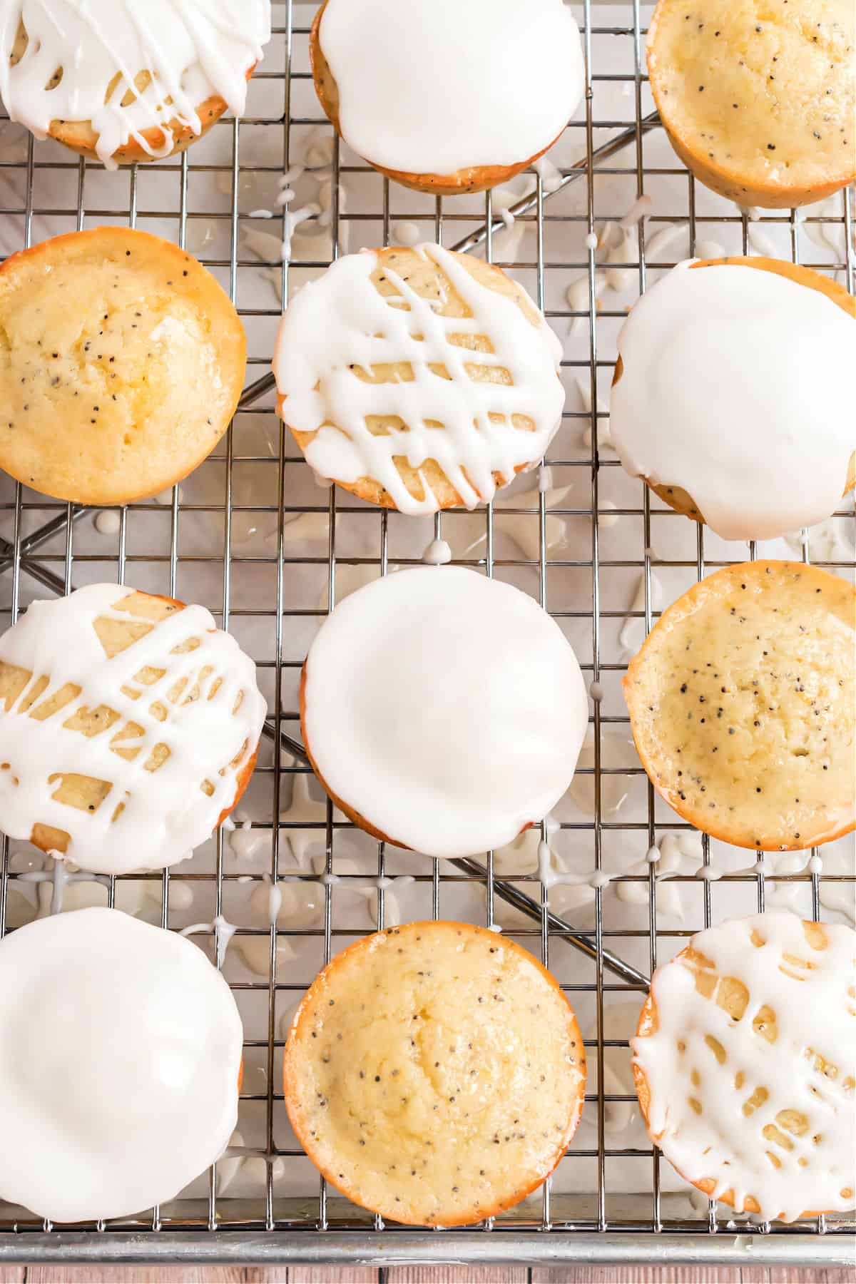 Muffins on a wire rack with icing.