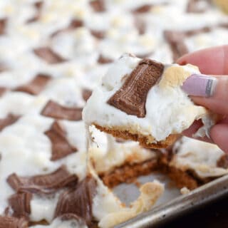 Piece of cracker toffee topped with candy bars and marshmallows.