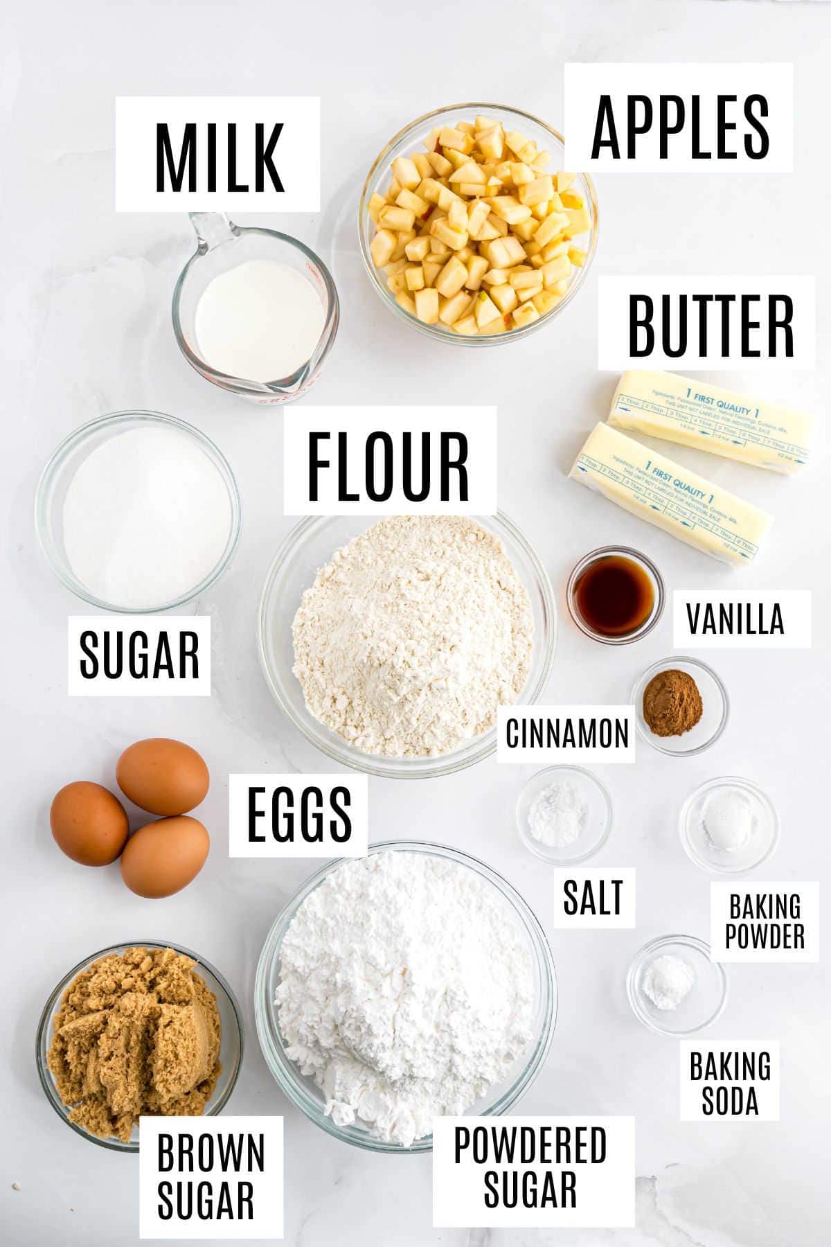 Baking ingredients labeled: milk, apples, butter, flour, sugar, eggs, brown sugar, powdered sugar, vanilla, and spices—everything you need for a delicious caramel apple bundt cake.