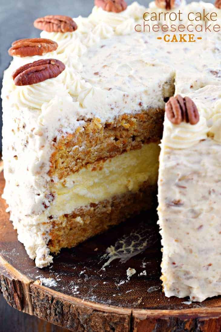 This Carrot Cake Cheesecake Cake is a showstopper! Layers of homemade carrot cake, a cheesecake center and it's all topped with a delicious cream cheese frosting! #carrotcake #cheesecake #cake #easter Carrot Cake Cheesecake Cake on a wooden cake plate with one slice removed.