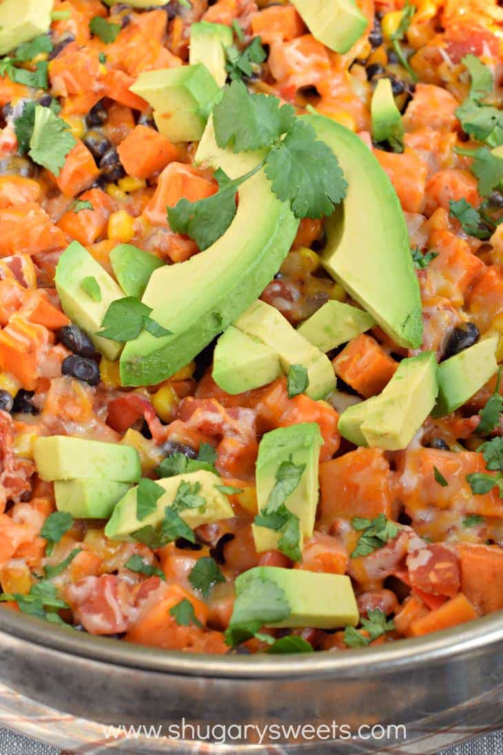 Skillet with sweet potato mixture and fresh avocado.