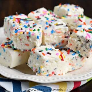 Pieces of fudge with sprinkles on a white plate.