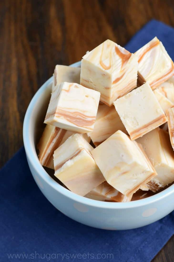 Light blue bowl with pieces of caramel swirled vanilla fudge pieces.