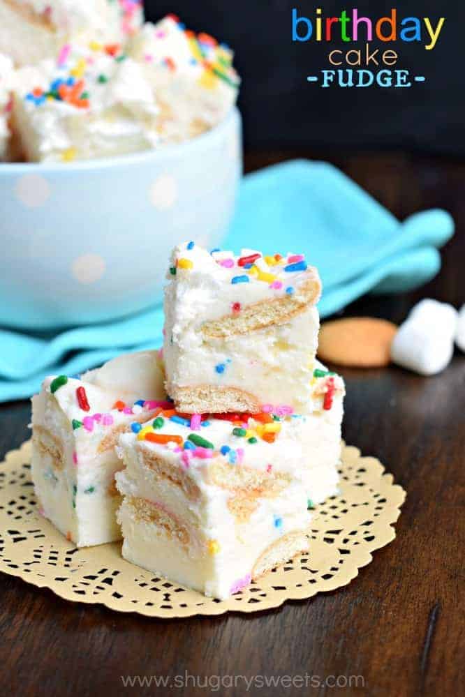 Three pieces of fudge stacked on a wooden counter.