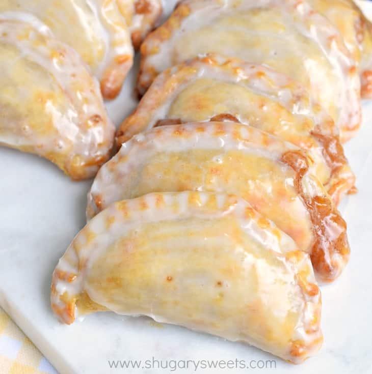 Dessert is ready in 30 minutes with these Glazed Peach Hand Pies! The flaky crust and spicy cinnamon filling are the perfect combo in a hand pie, plus they're baked not fried! Peach hand pies with vanilla glaze.