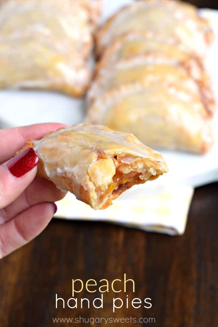 Dessert is ready in 30 minutes with these Glazed Peach Hand Pies! The flaky crust and spicy cinnamon filling are the perfect combo in a hand pie, plus they're baked not fried! Peach hand pie with one bite removed.