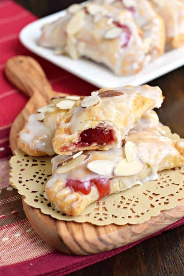 Easy, baked Cherry Almond Hand Pies! A flaky crust with a cherry almond pie filling, dipped in a sugary glaze and topped with sliced almonds. The perfect dessert!