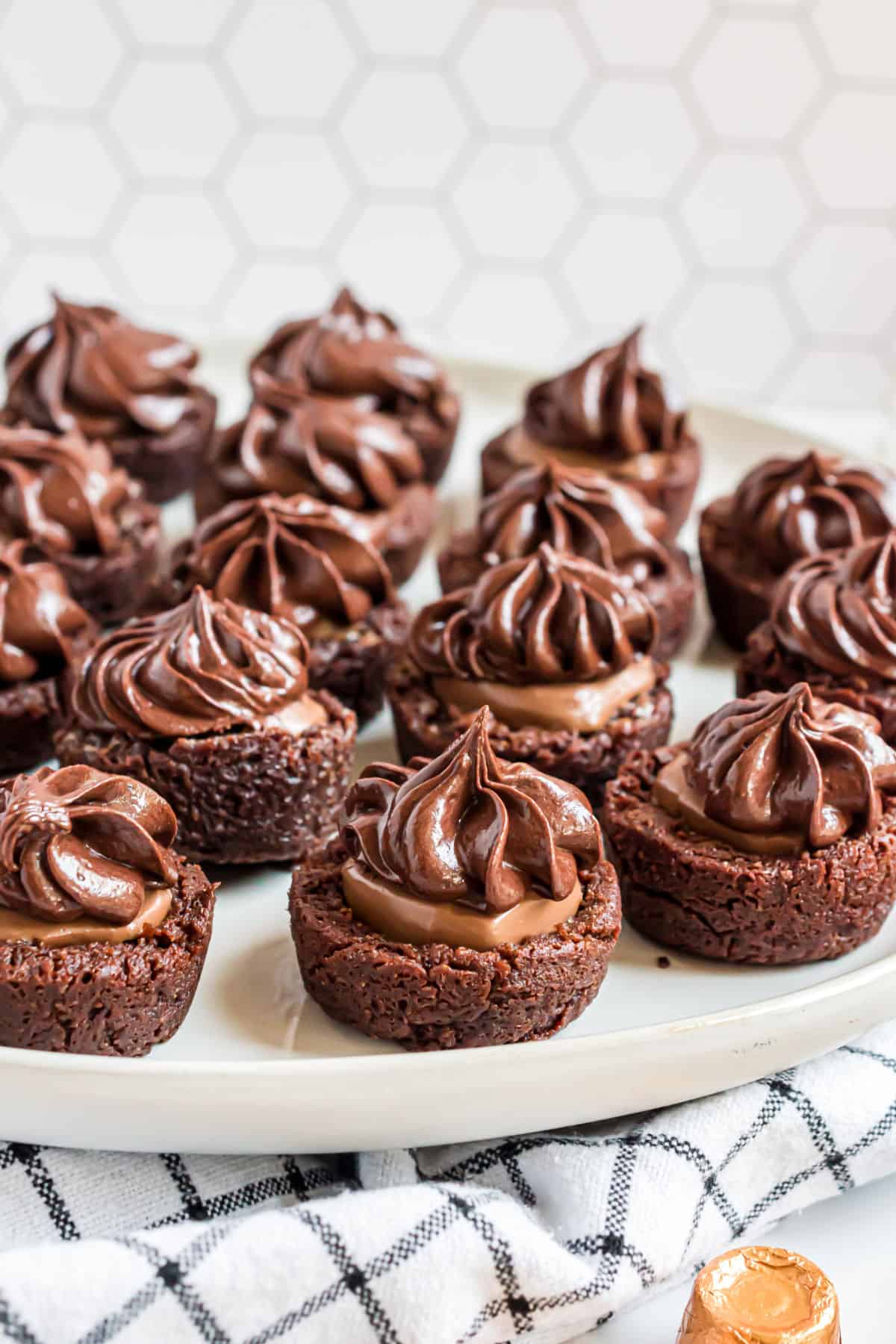 Chocolate caramel brownie bites on a cake platter to serve.