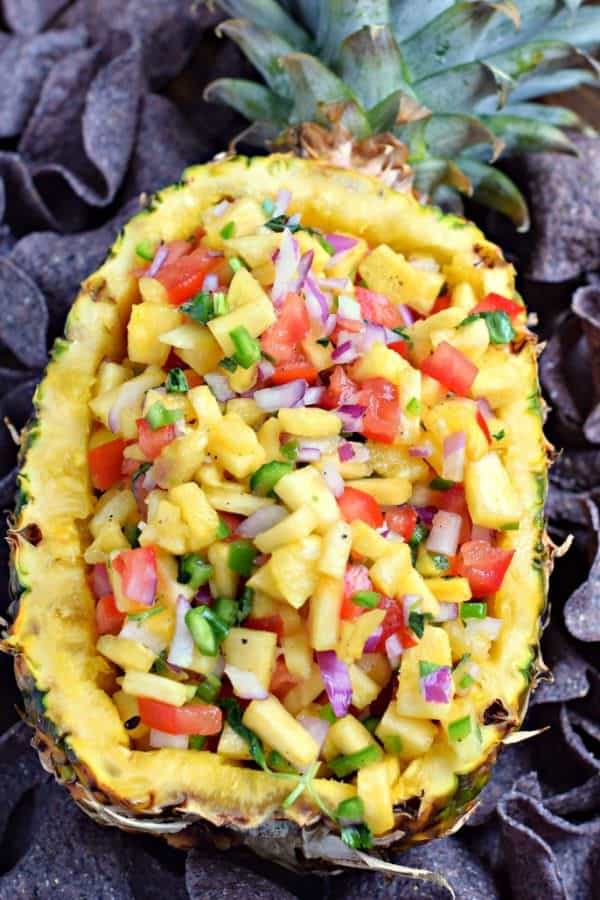 Pineapple salsa served in a pineapple with tortilla chips.
