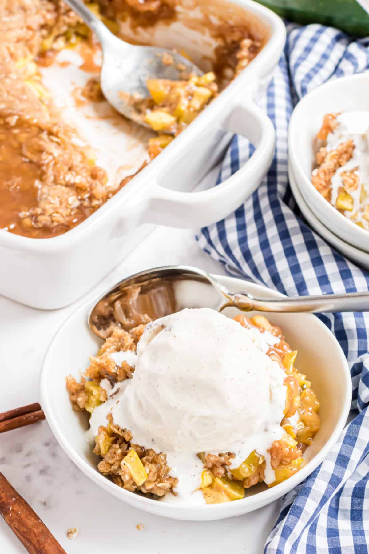 White bowl with zucchini crumble and vanilla ice cream.