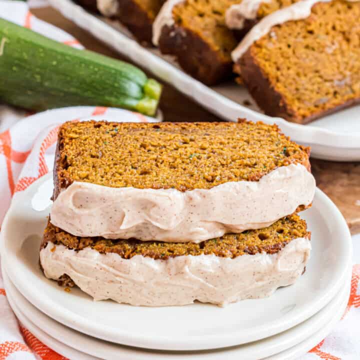 Pumpkin Zucchini Bread is an incredibly moist, flavorful treat topped with a cinnamon cream cheese frosting. This recipe makes two freezer friendly loves —one for now and one to save for later!