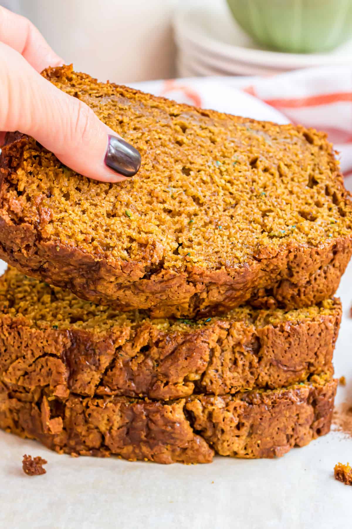 Three slices of pumpkin zucchini bread stacked on top of each other.